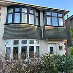 Double-glazed bay window installation on a residential home, showcasing high-quality UPVC window frames.