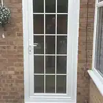 Upvc glazed back door with decorative grid design, white frame, and glass panel.