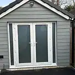 Double glazed PVCu French doors with frosted glass, grey siding, and black roof tiles.
