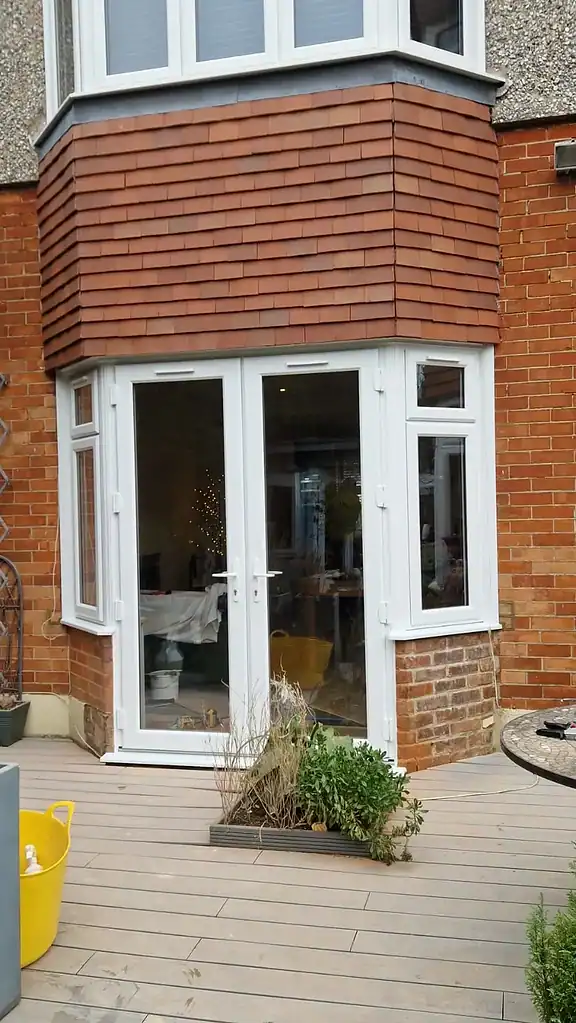 Modern white PVC patio doors with side windows for home extension, double-glazed for insulation.