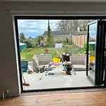 Modern aluminium bi-fold door installation with patio outside, showcasing high-quality glazing solutions.