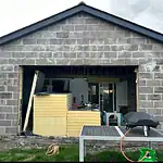 Bi-folding door installation in an extension with brick exterior, under construction by CP Glazing Ltd.