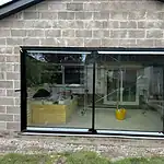Double glazed sliding patio doors installation in a residential brick wall for energy efficiency and security.