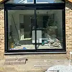Modern black-framed glass extension with a pitched roof, described on CP Glazing Ltd website.