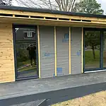 Modern bi-fold glass doors installed on a wooden exterior wall for increased natural light and outdoor access.