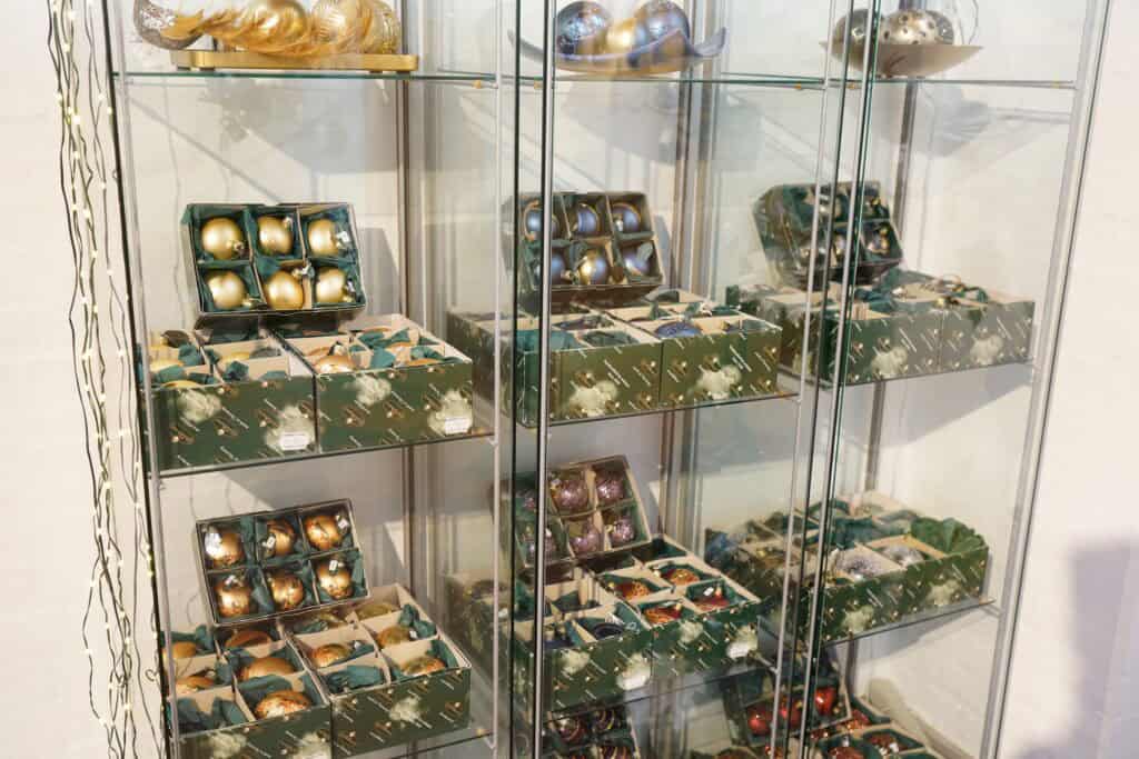 Hængende juleornamenter i glas på displayhylder, smukt kunstcenter i Dronninglund, Danmark.