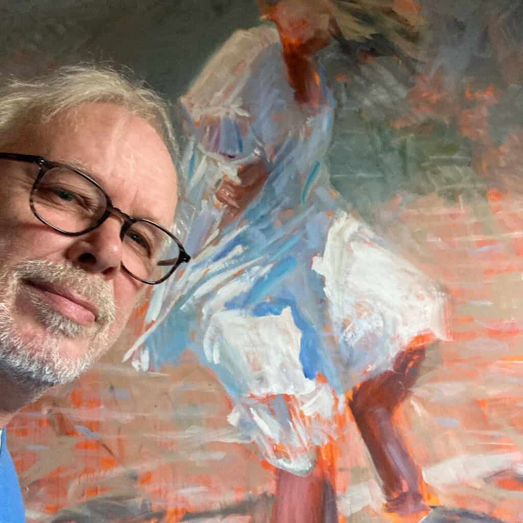 Kunstner står foran et farverigt maleri i Dronninglund Kunstcenter.
