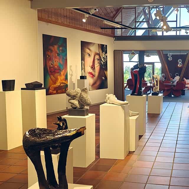 Udstillingsrum med moderne kunstværker og skulpturer i Dronninglund Kunstcenter.