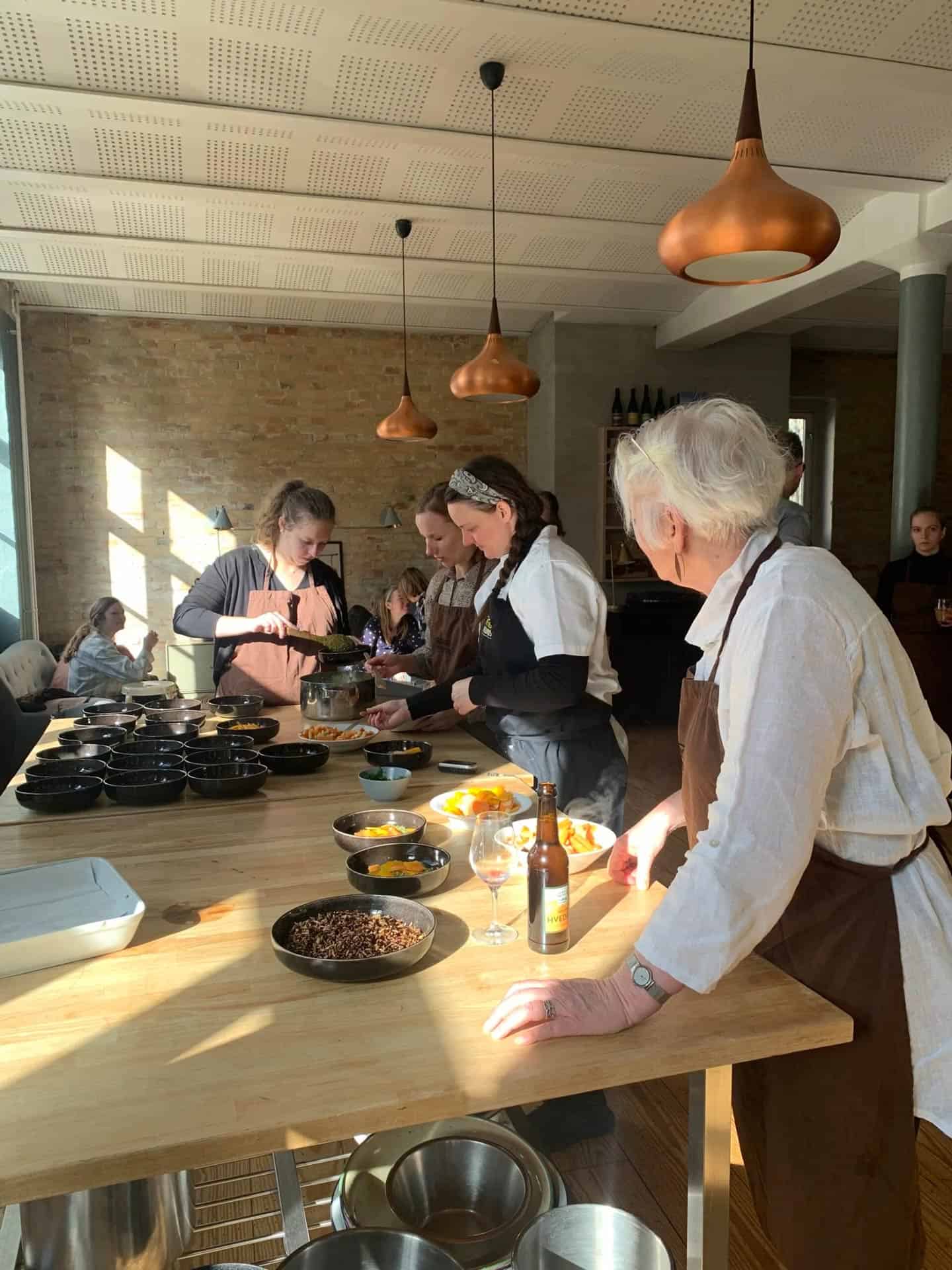 Mennesker samlet til fællesspisning i fælleskøkkenet, der er en del af bofællesskaberne hos EcoVillage.