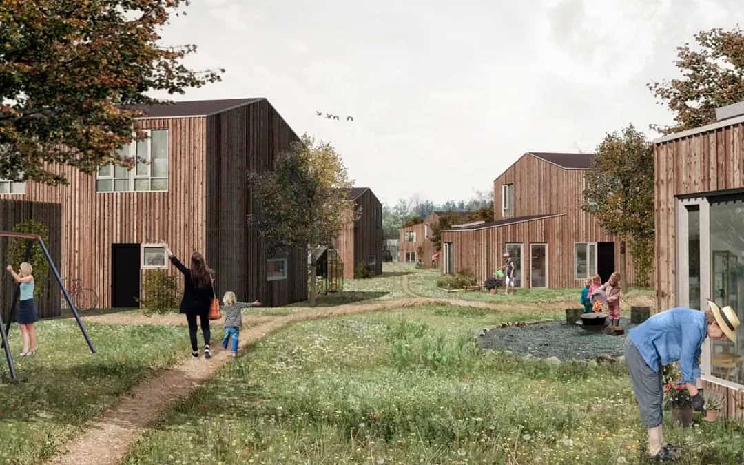 Træhuse på grøn mark i et morderne og bæredygtigt bofællesskab på Sjælland.