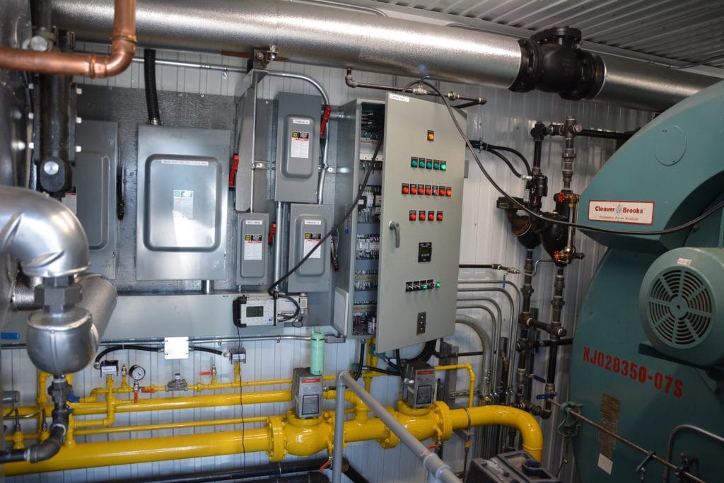 Mobile boiler rental Panneau de contrôle électrique et système de tuyauterie de gaz naturel raccordés à une chaudière industrielle Cleaver-Brooks chez Ecowaterlab.