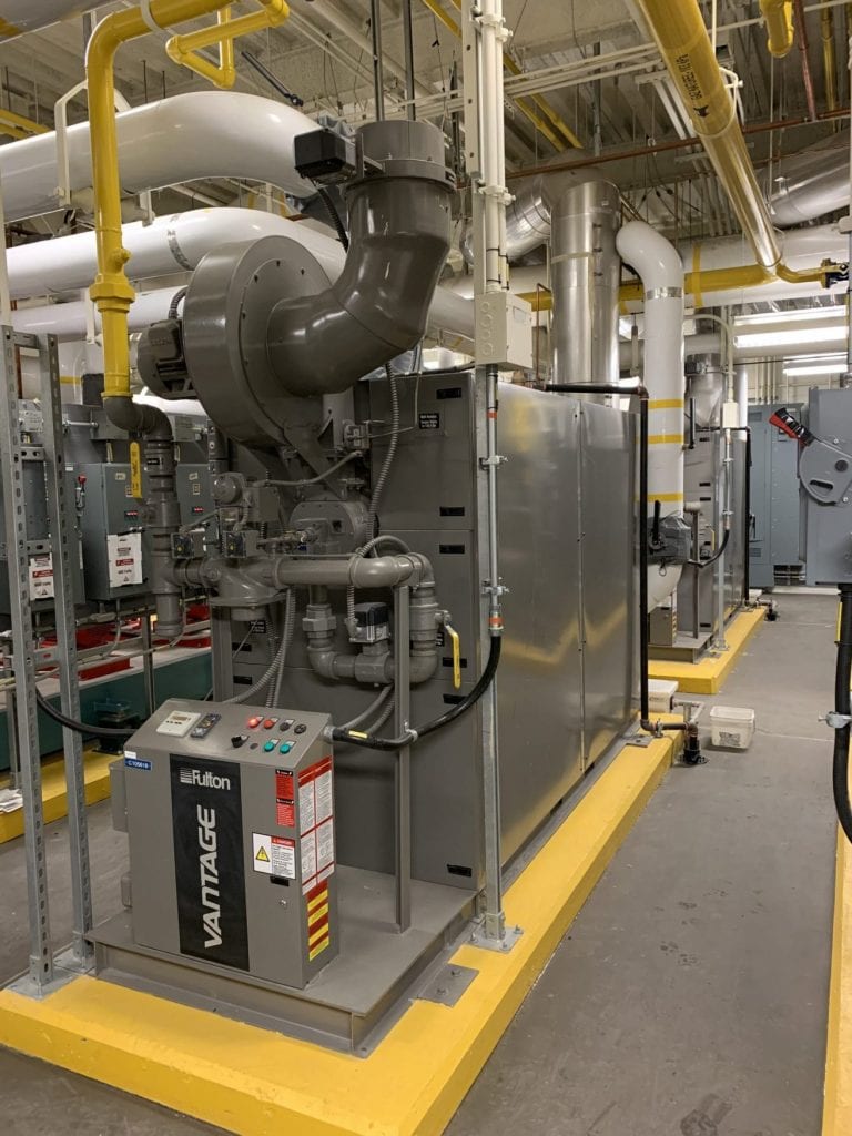 Chaudière à condensation industrielle Fulton Vantage installée dans une salle mécanique moderne avec tuyauterie de gaz naturel et système d’évacuation.