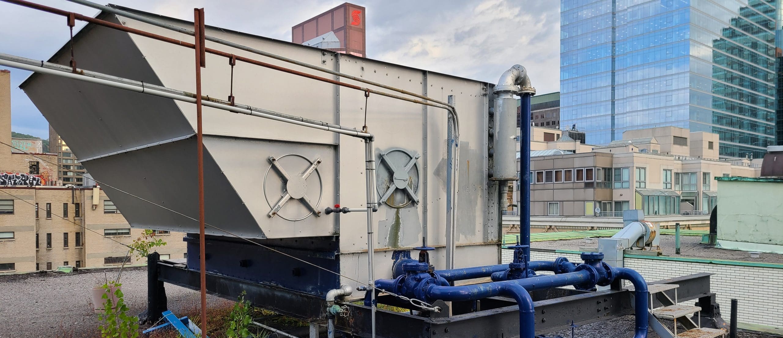Tour d’eau de refroidissement industrielle sur un toit, utilisée pour le rejet de chaleur dans les systèmes de CVC ou de procédés industriels.