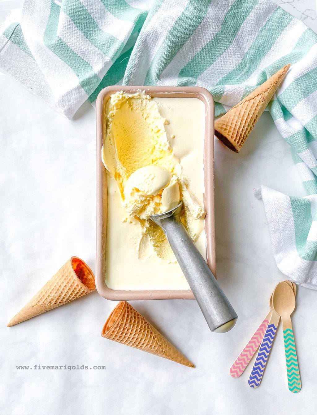 Loaf pan filled with marshmallow vanilla ice cream and ice cream scoop