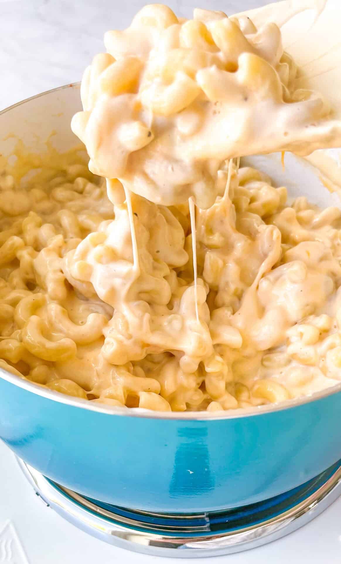 Blue pot with spoon scooping out macaroni and cheese