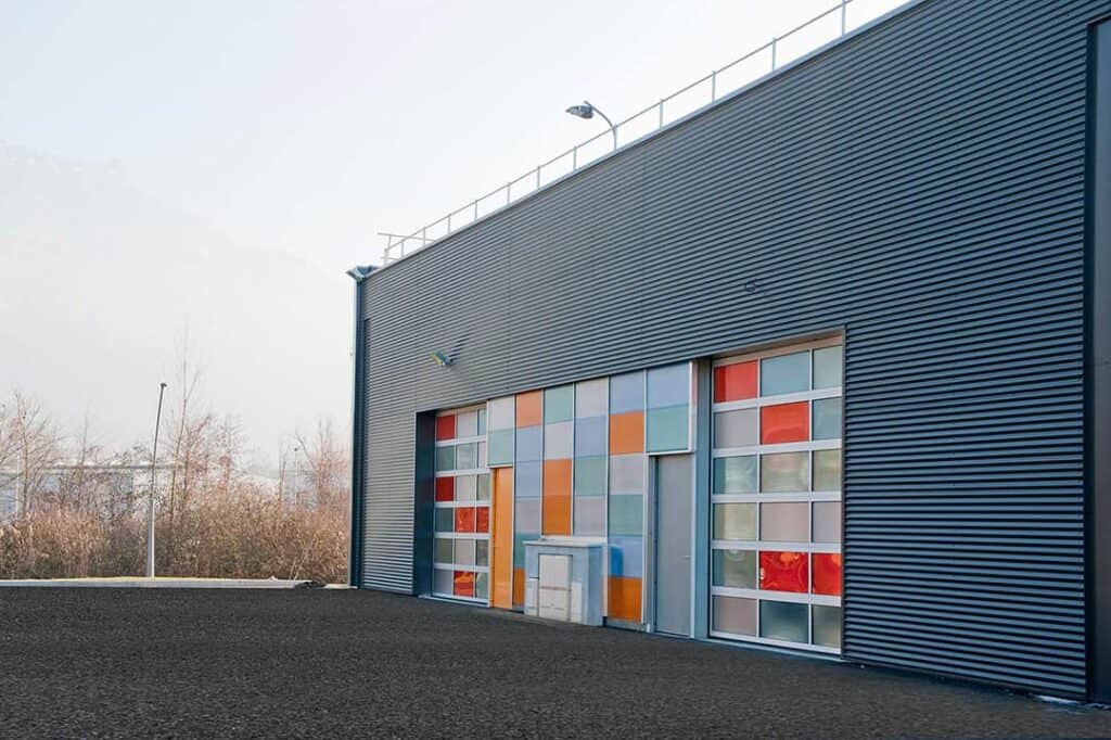 Glasfacade med farvede paneler ved indgangsparti