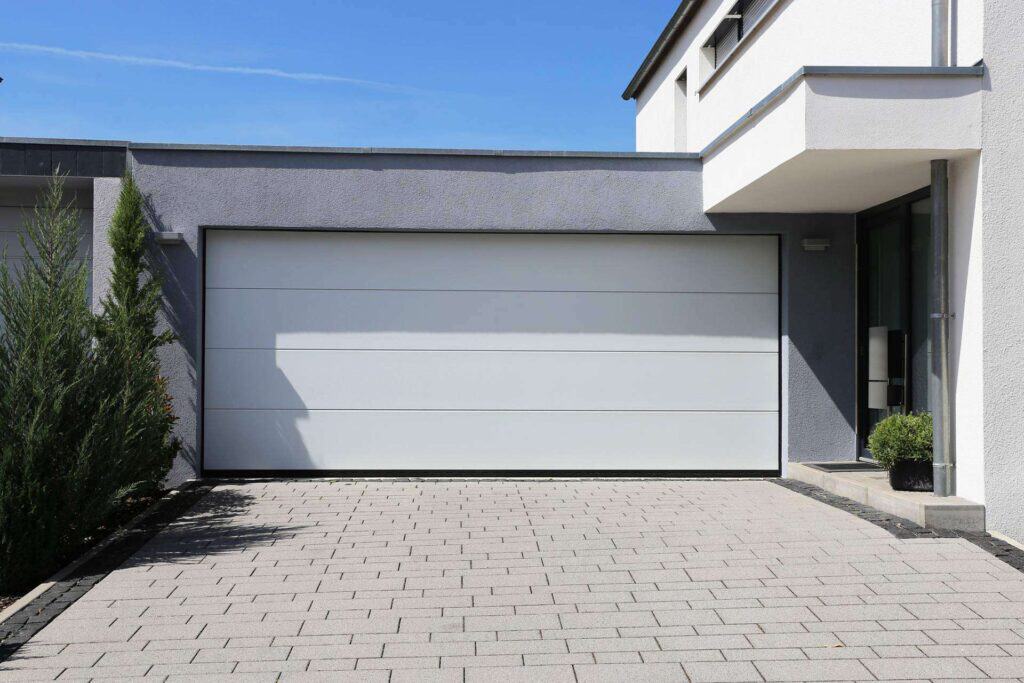 Montering af hvid garageport på moderne villa