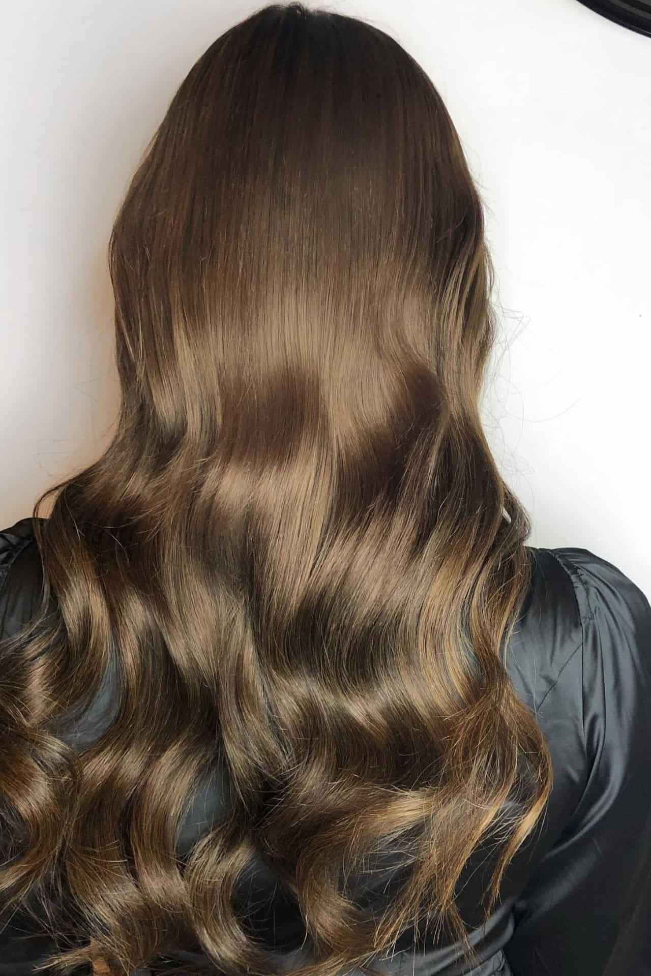 Hårfarvning og styling af langt brunt hår med fald.