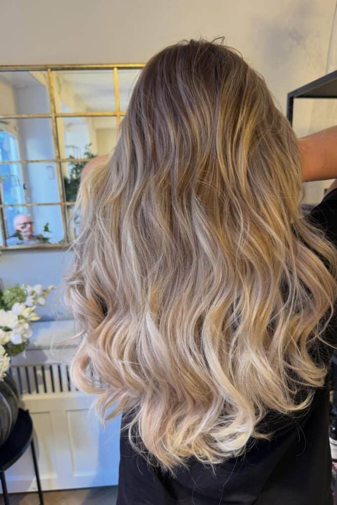 Askeblondt hår med fald set bagfra i frisørsalon.
