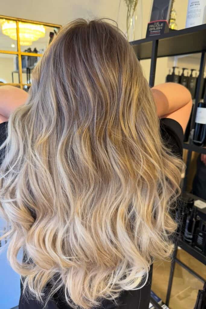 Styling af mellemlangt blondt hår med fald og balayage.