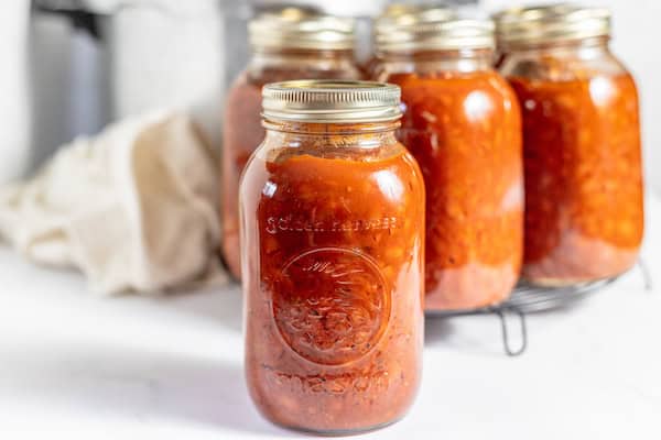 jars of homemade baked beans with a pressure canner in the background