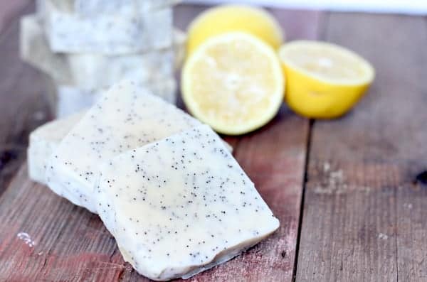 Image shows several bars of soap on a table, with lemon halves nearby