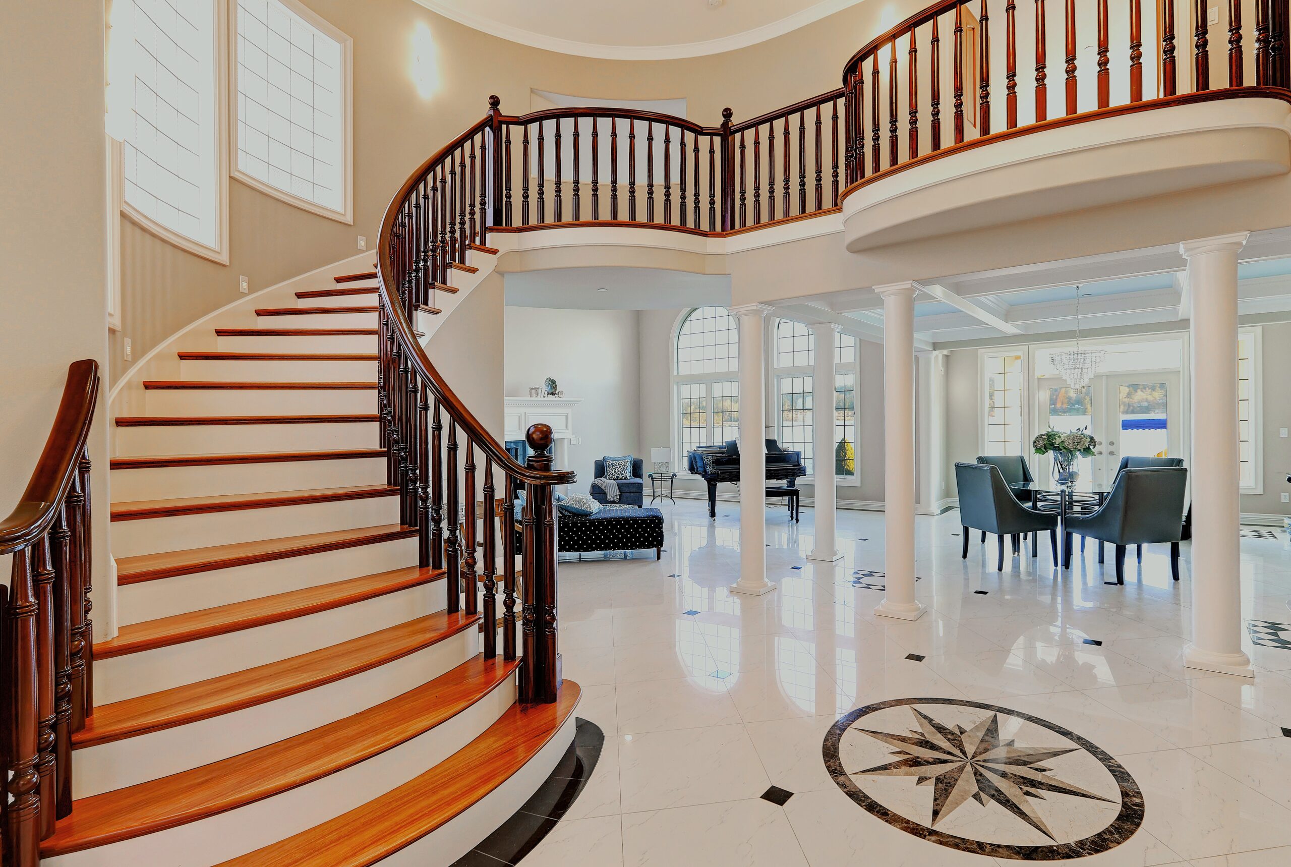 Elegant great room with sweeping staircase professionally photographed.