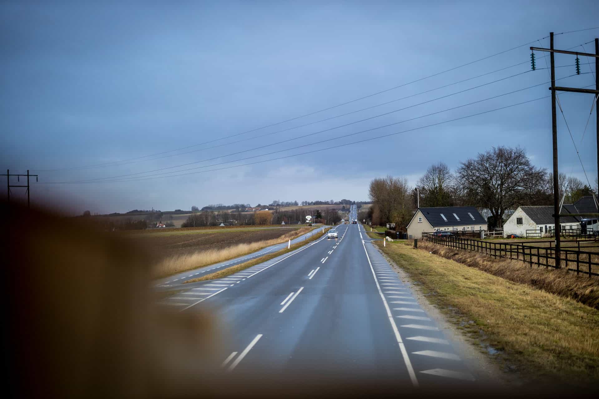 Udsigt fra førerhuset gennem forruden under en køretur på en landevej.
