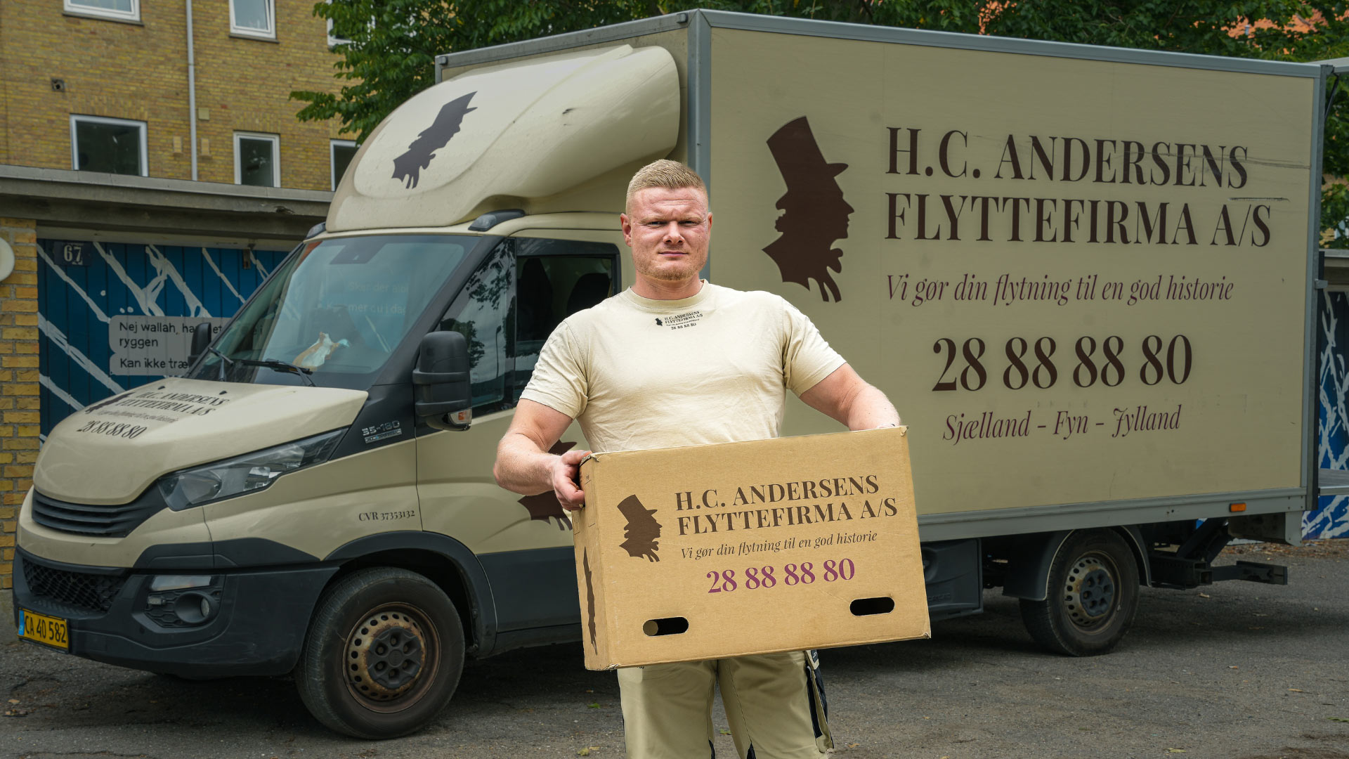 Flyttefirma i Hillerød, hvor en flyttemand løfter en kasse for en kunde