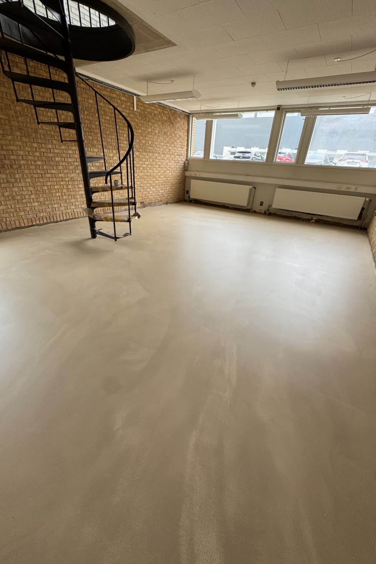 Lyst og rengøringsvenligt polyurethan gulv i et moderne showroom udført af Jysk Gulvmontering