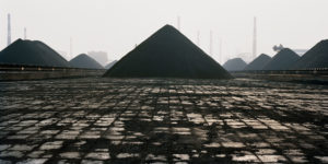 Piramid shaped mounds in an industrial landscape. Edward Burtynsky, China.