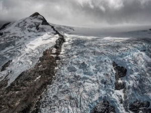 A large glacier is shown in the sky. Edward Burtynsky Coast Mountains, Iceland. Coast Mountains series.