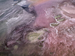 Colorful salt flats stretching across a vast landscape in pink and purple tones. Edward Burtynsky, African Studies series.