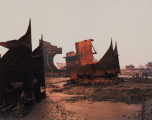 Broken ship components scattered across a muddy field. Edward Burtynsky Shipbreaking