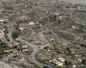 Winding muddy roads with dilapidated tents and structures. Edward Burtynsky, China
