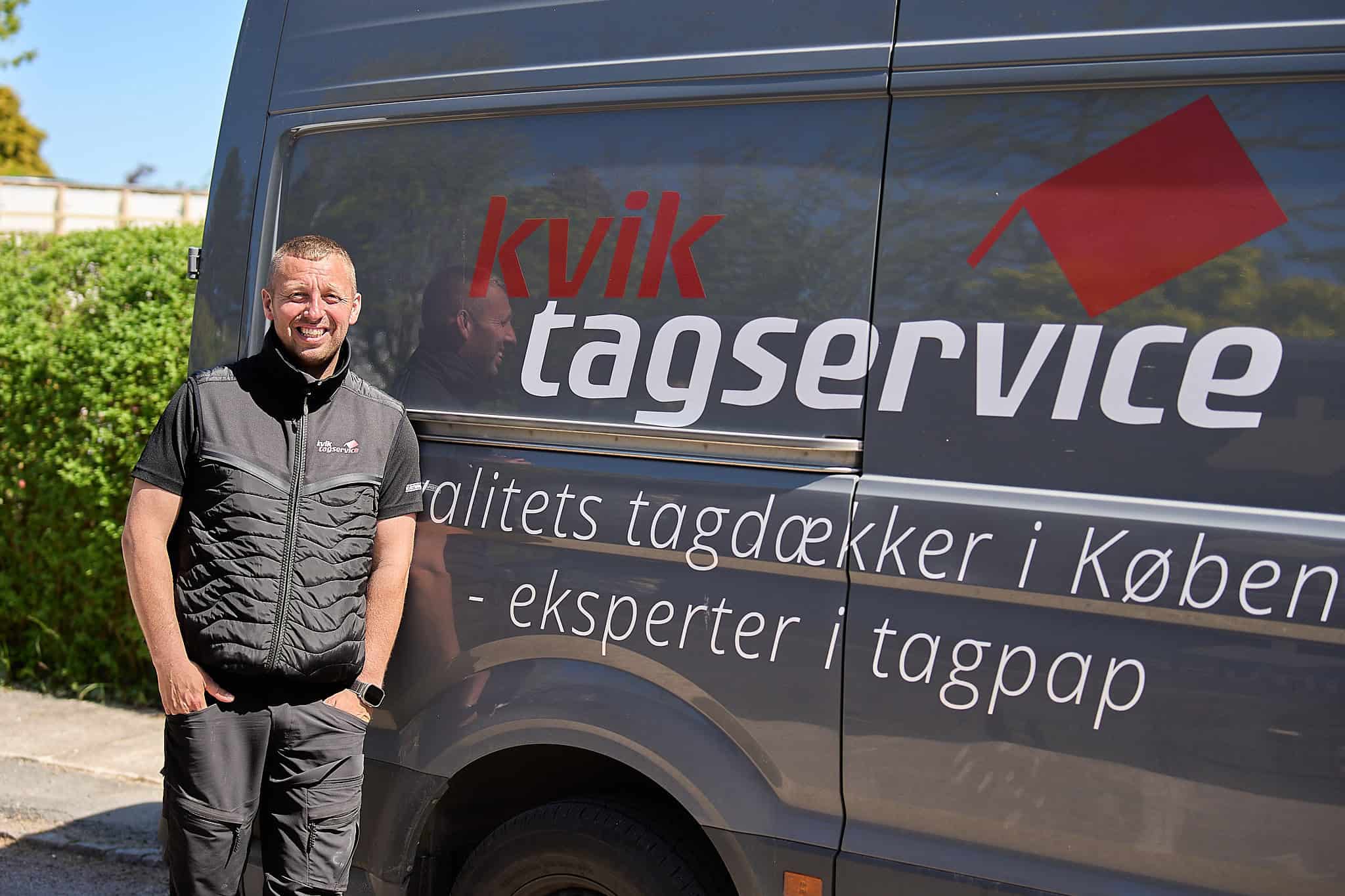 Glad, kortklippet tagdækker i quiltet vest ved KvikTagservice bil