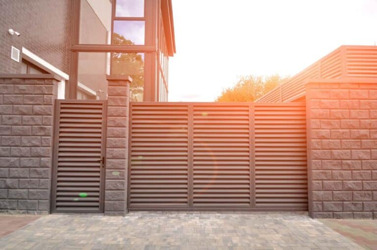 Newly installed automatic driveway gate in modern style, slate-grey aluminium horizontal slats