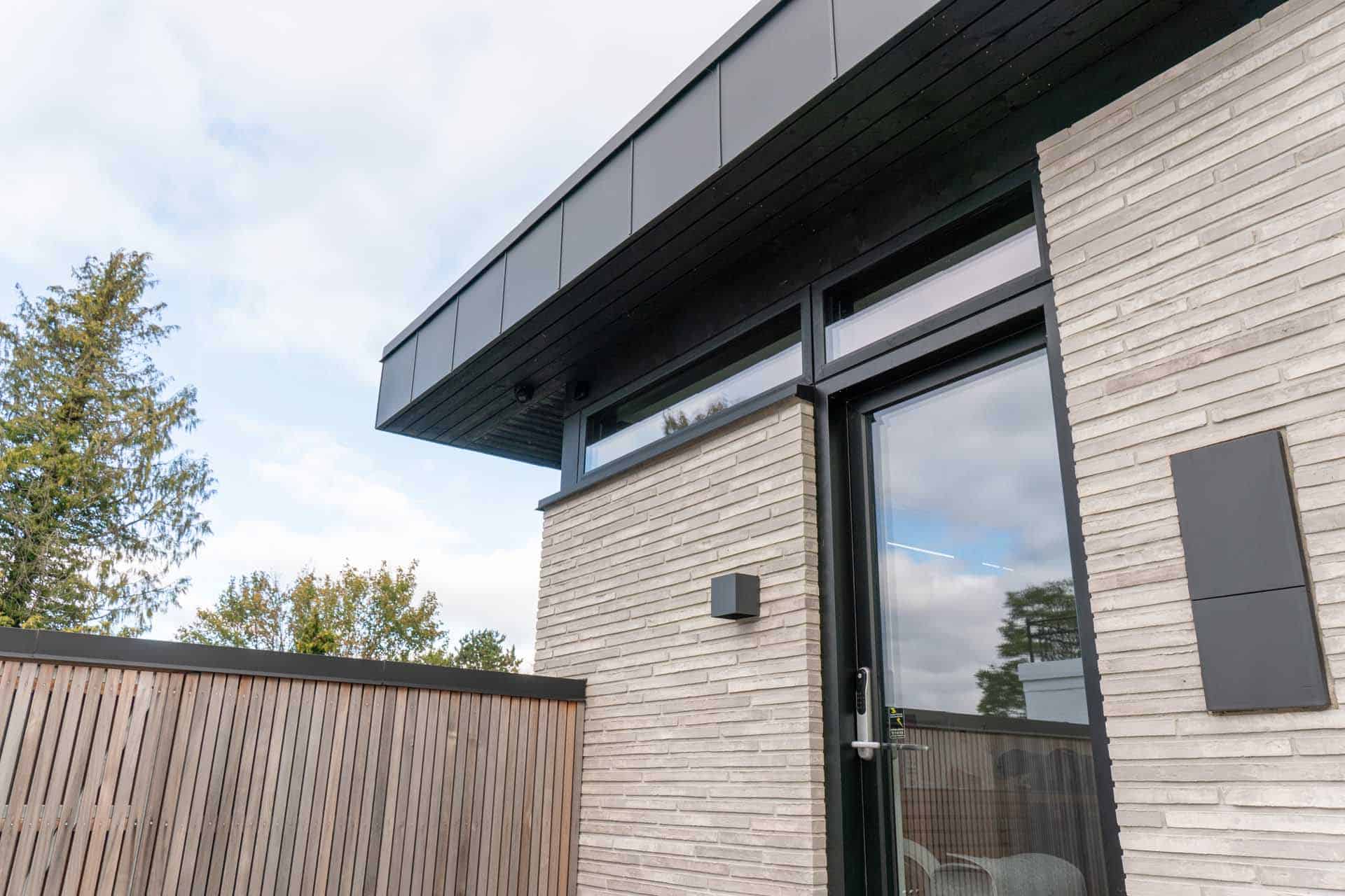 Glashjørne i gårdhave med glidende overgang til fliser.