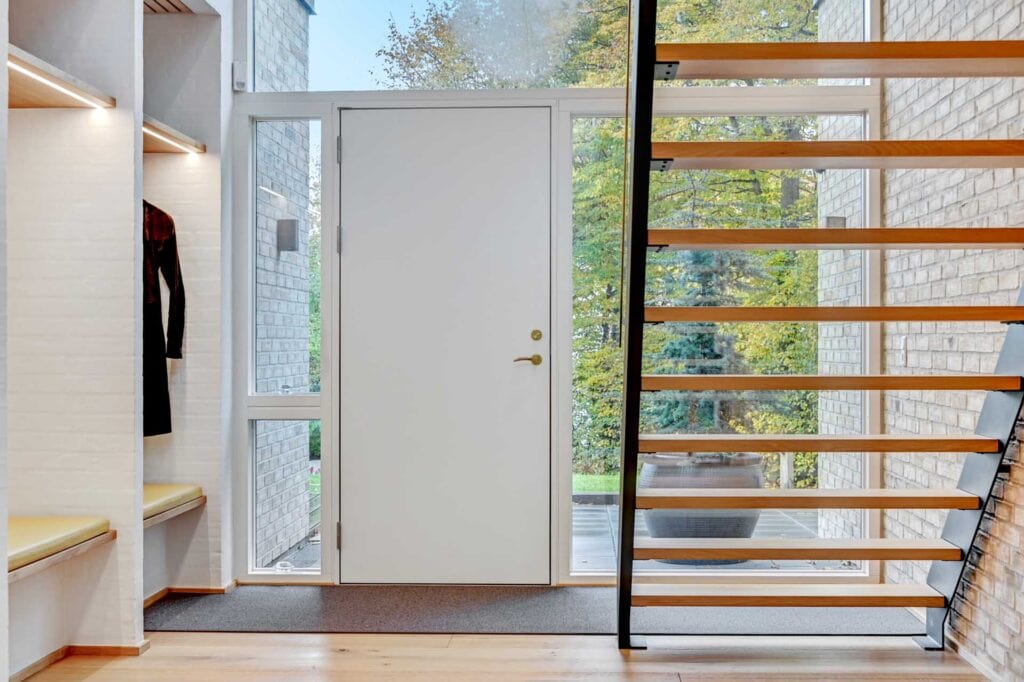 Lys entré med kig til trappe i villa fra LTM Arkitekt- og byggefirma.