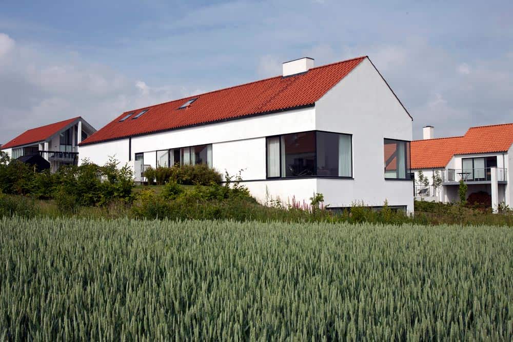 Moderne hvidt hus i Ugelbølle omgivet af grøn have.