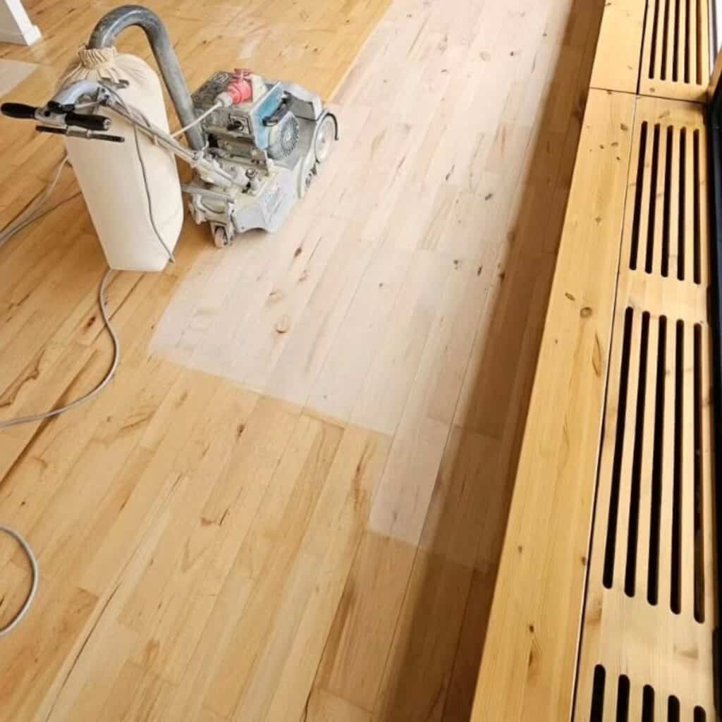 Gulvslibningsmaskine i køkken under en igangværende gulvafslibning.
