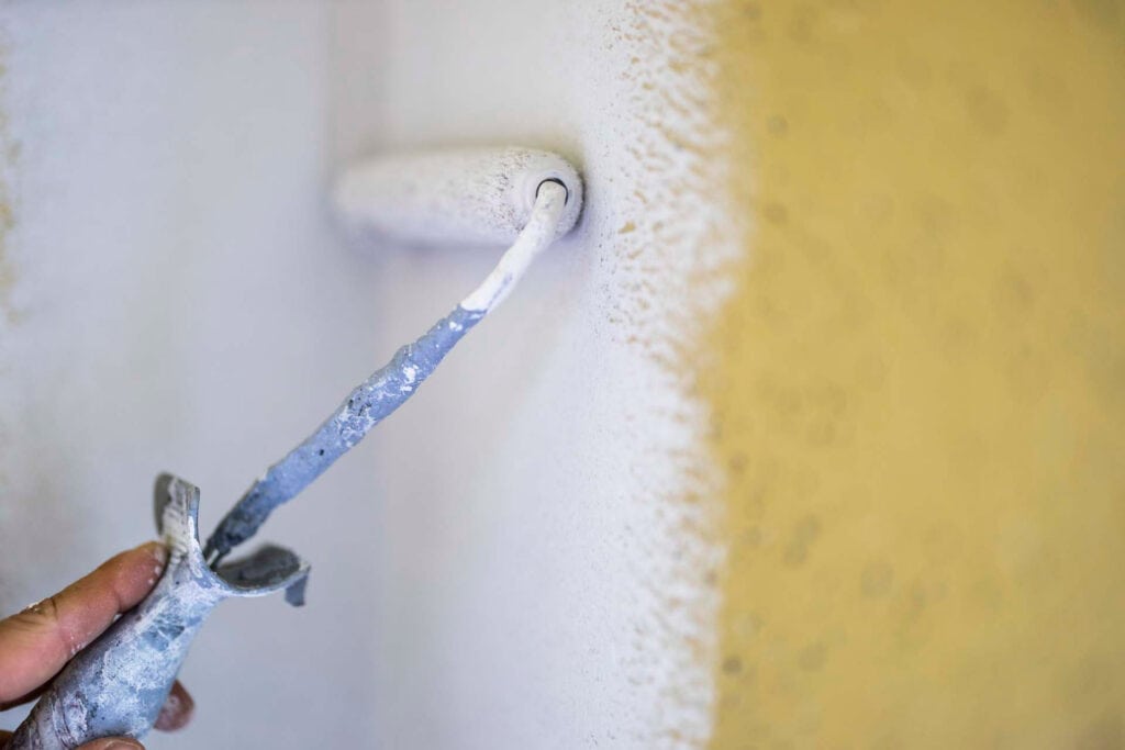 Maler maler væg med malerrulle