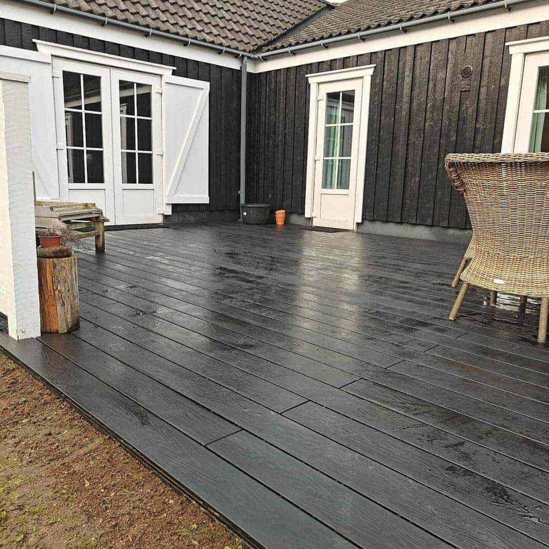 Mørk bejdset træterrasse ved sort sommerhus udført af tømrer i Hellerup