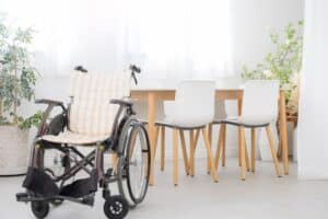 Wheelchair beside dining table in bright modern room