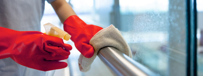 Person in red gloves cleaning metal railing