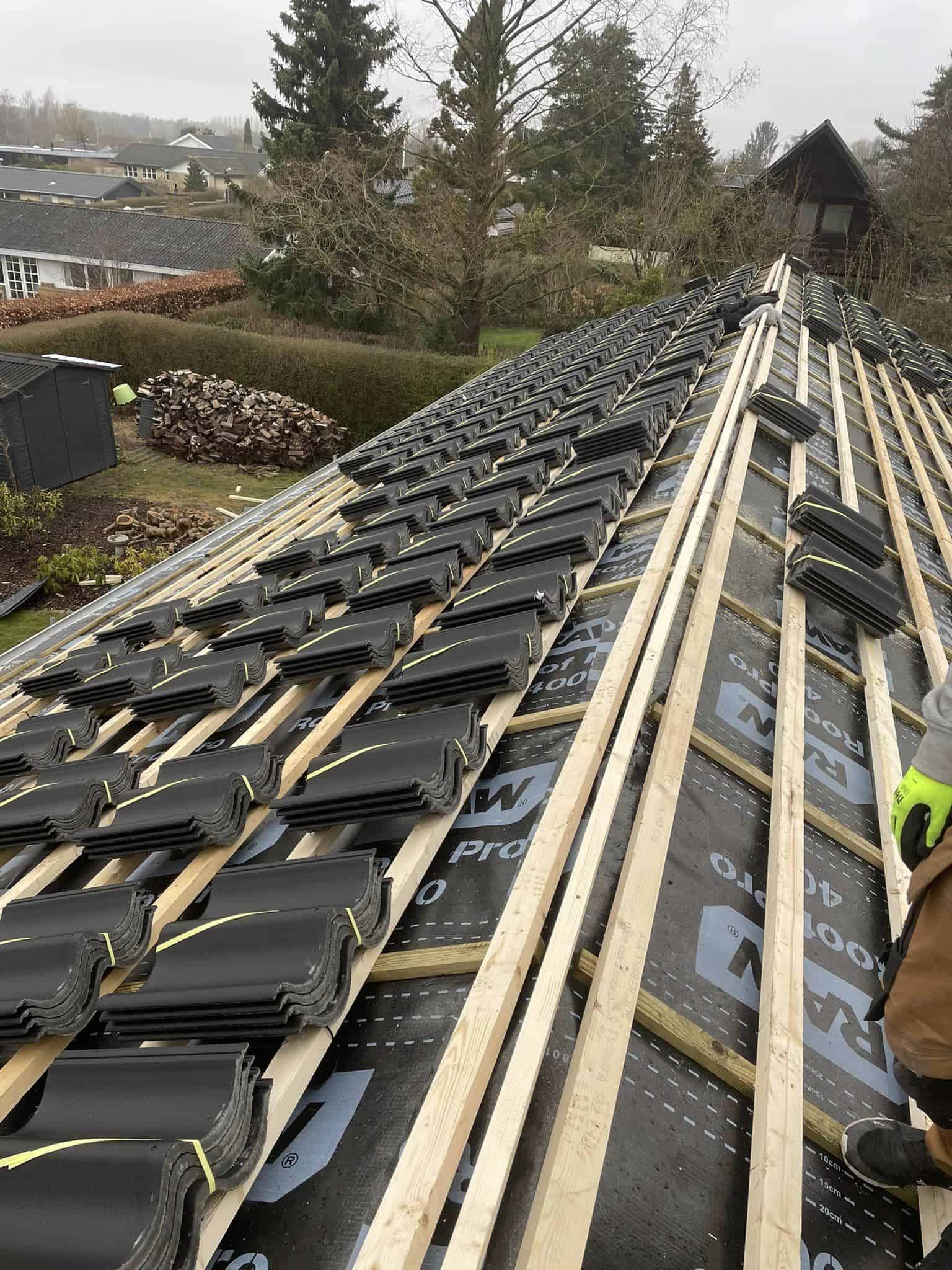 Igangværende renovering af tag med sorte tegl