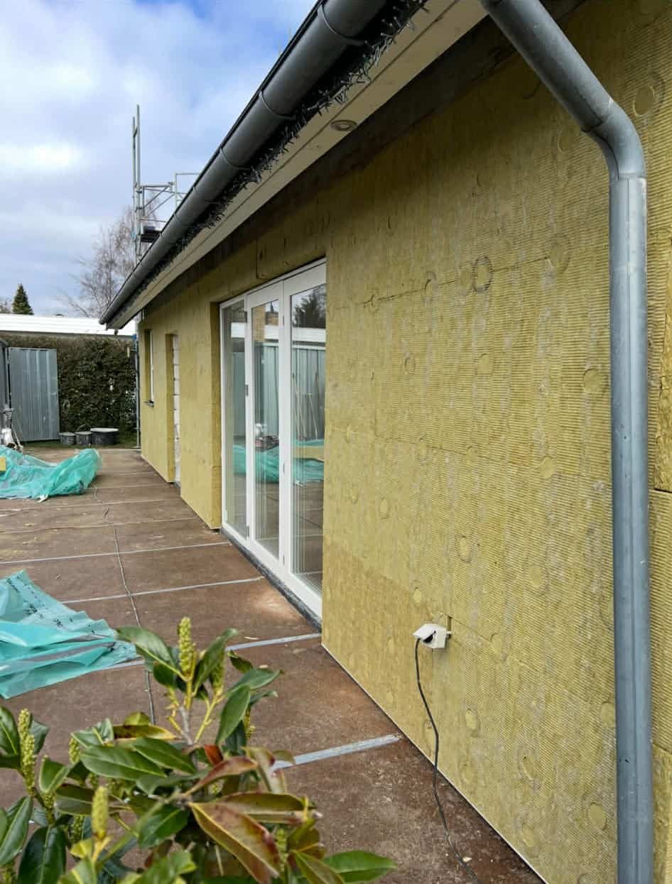 Facadeisolering af en husmur med gule isoleringsplader