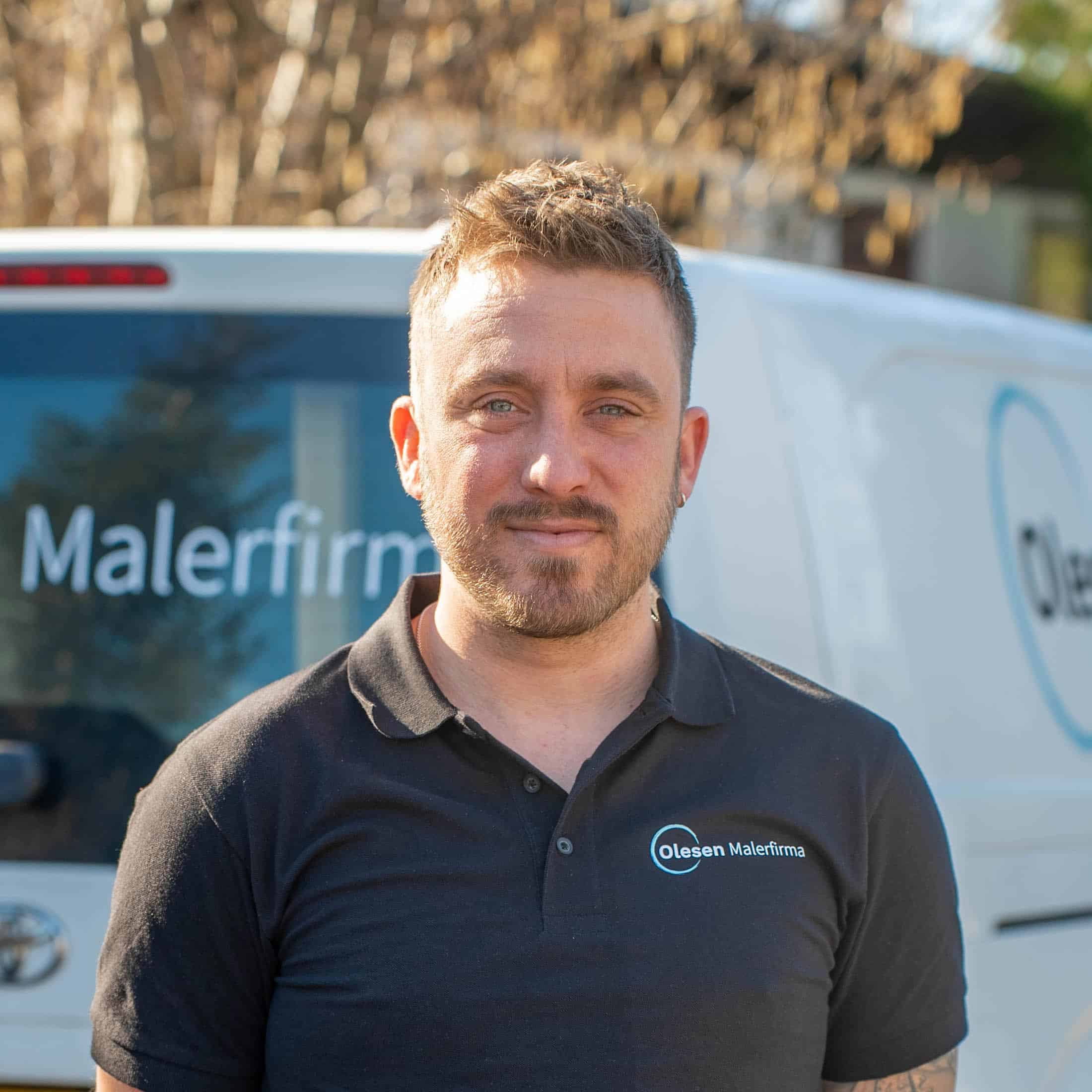 Portræt af professionel maler stående foran hvid bil