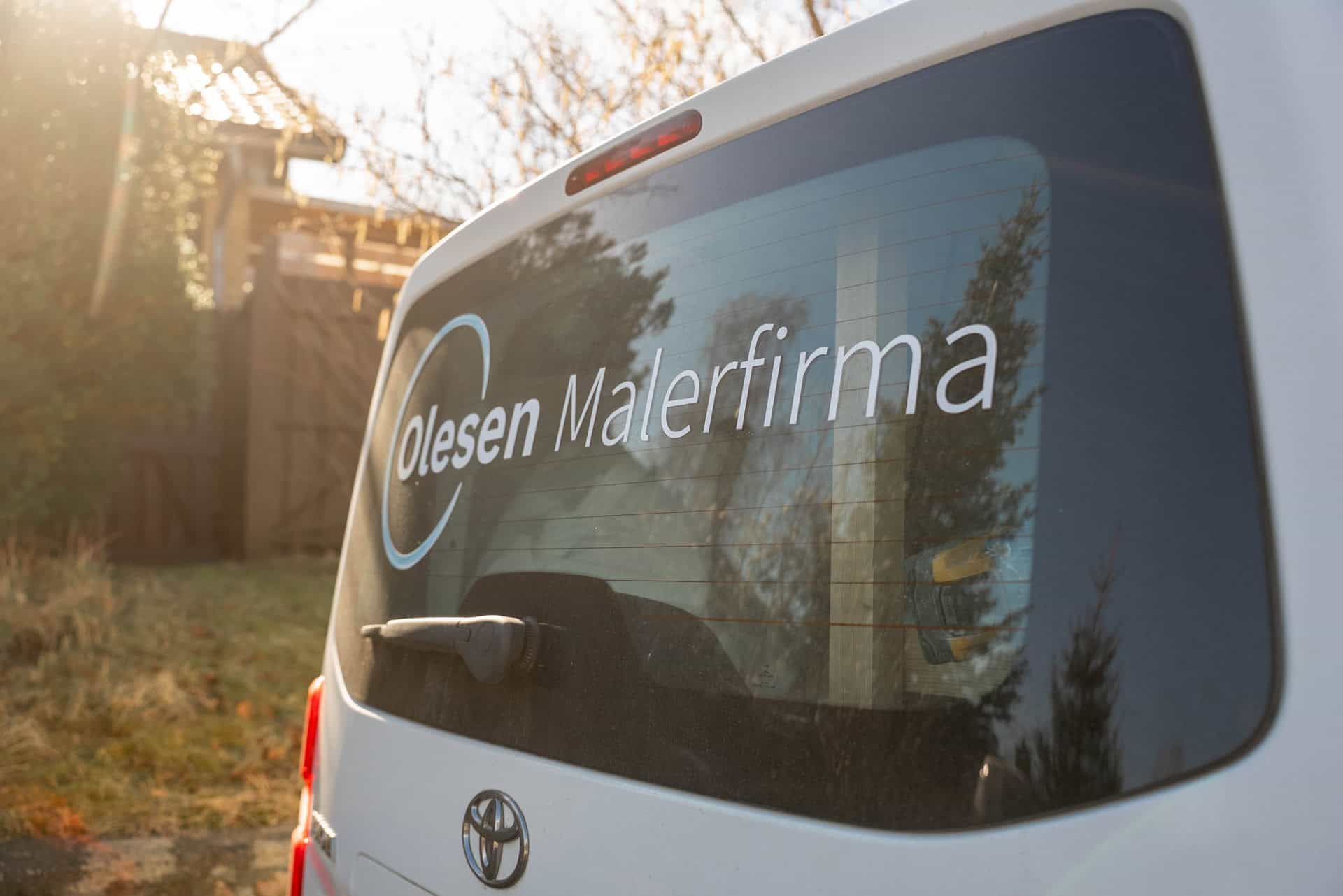 Bagenden af hvid varebil - "Olesen Malerfirma"