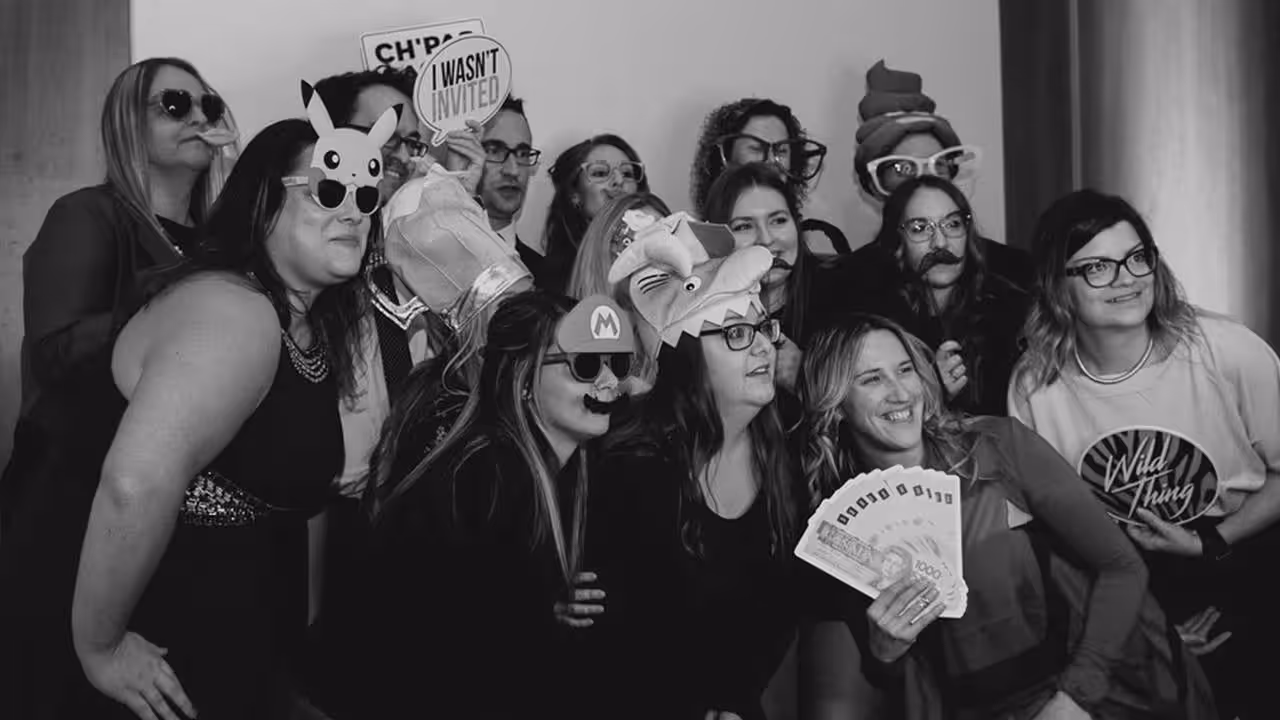Photo booth avec groupe de personnes déguisées et souriantes lors d’un événement festif.